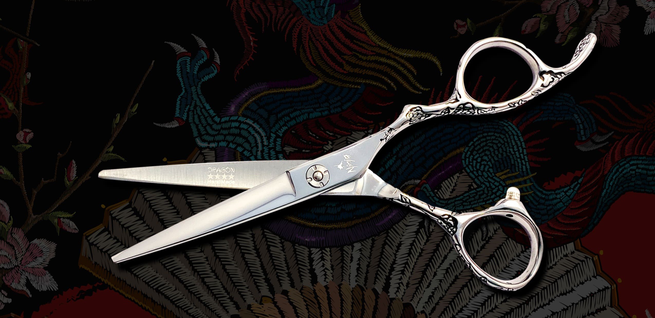 Silver hair shears on dark embroidered dragon fabric